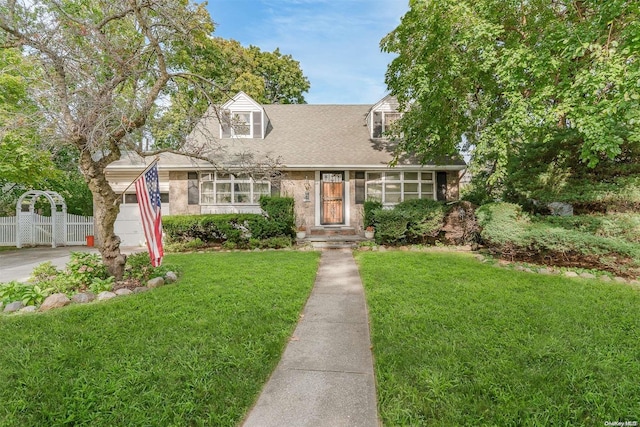 new england style home with a garage and a front lawn