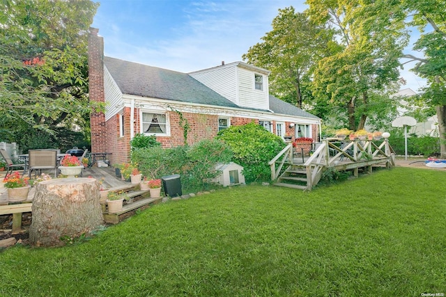 rear view of property with a lawn and a wooden deck