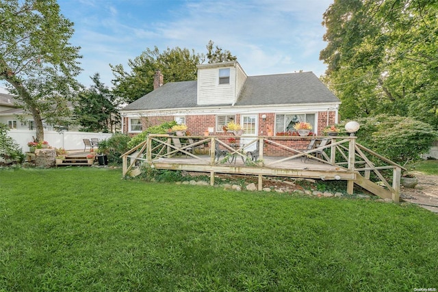 rear view of house with a yard and a wooden deck