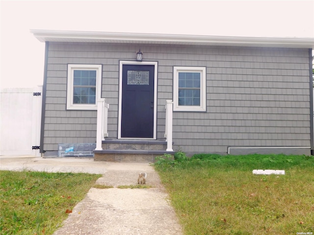 view of exterior entry featuring a yard