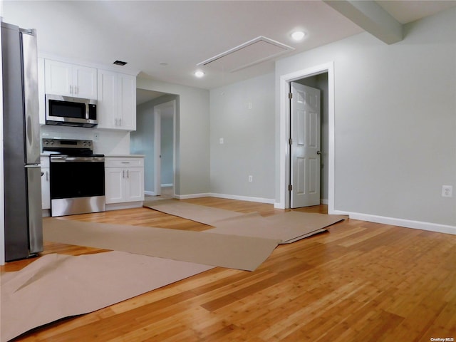 kitchen with light hardwood / wood-style floors, white cabinetry, and appliances with stainless steel finishes