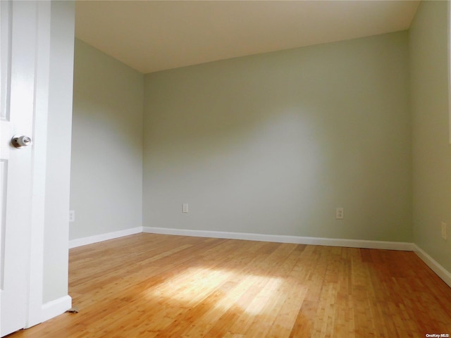 unfurnished room with hardwood / wood-style flooring