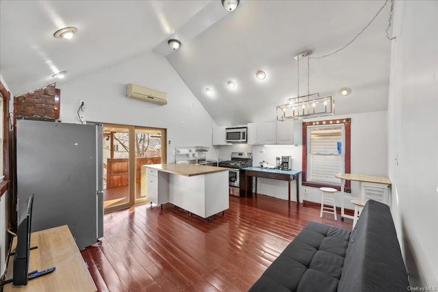 kitchen with pendant lighting, a center island, high vaulted ceiling, white cabinetry, and stainless steel appliances