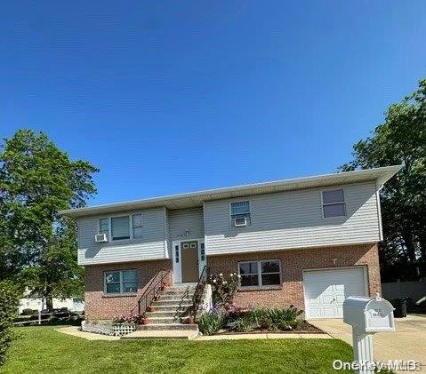 split foyer home with a front yard and a garage