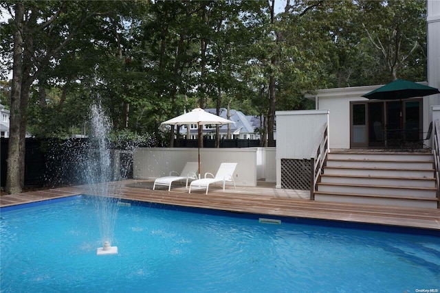 view of swimming pool featuring pool water feature and a wooden deck