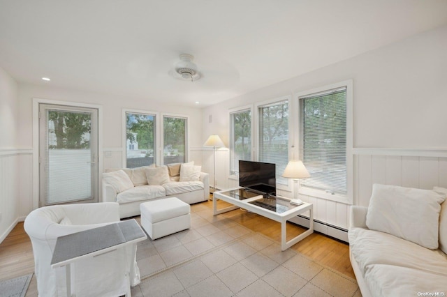 sunroom featuring ceiling fan and a baseboard radiator