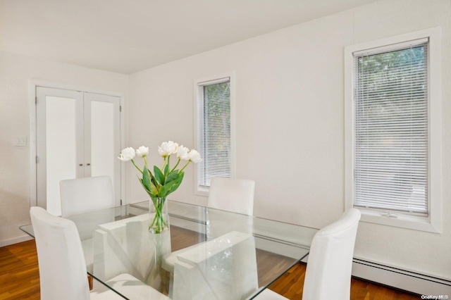 dining space with dark hardwood / wood-style flooring, a baseboard radiator, and french doors