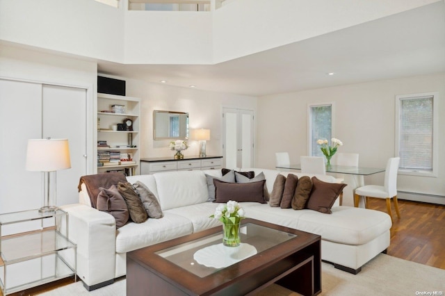 living room featuring a baseboard radiator and light hardwood / wood-style flooring