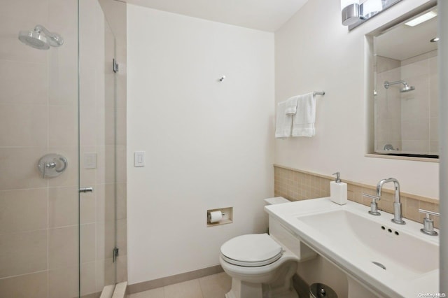 bathroom featuring tile patterned floors, sink, a shower with shower door, and toilet