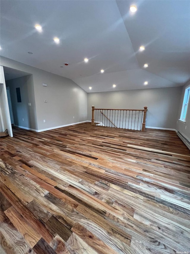 empty room with hardwood / wood-style flooring and vaulted ceiling