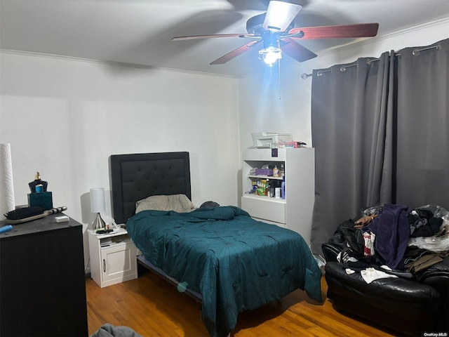 bedroom with light hardwood / wood-style flooring, ceiling fan, and ornamental molding