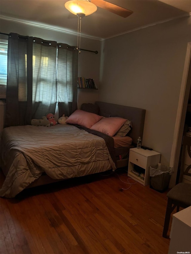 bedroom featuring ceiling fan, wood-type flooring, and ornamental molding