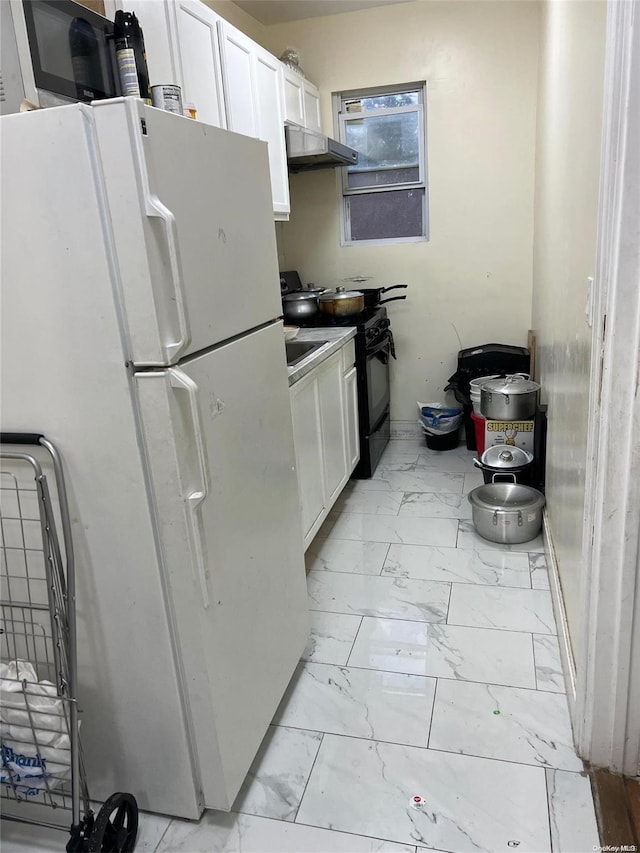 kitchen featuring white cabinetry, white fridge, and electric range