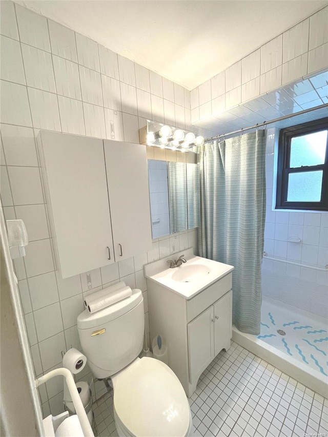 bathroom featuring curtained shower, tile patterned flooring, toilet, vanity, and tile walls