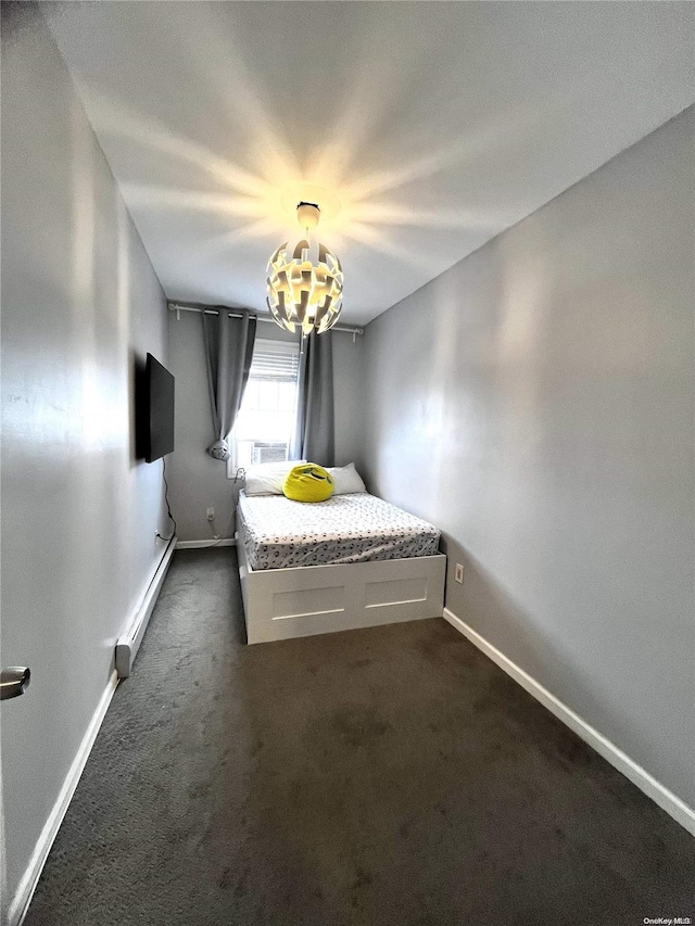 unfurnished bedroom with a baseboard radiator and dark carpet