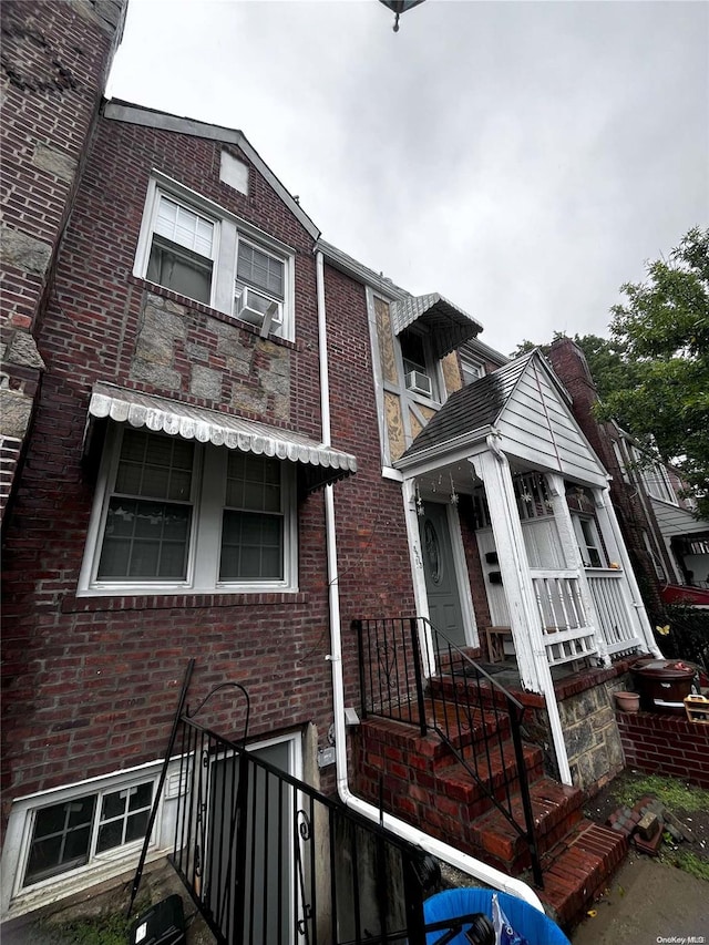 view of property featuring brick siding, central AC unit, and cooling unit