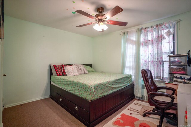 carpeted bedroom featuring radiator and ceiling fan