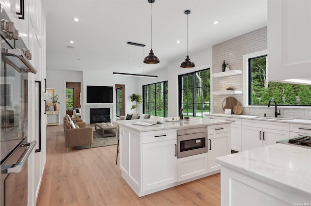 kitchen featuring light stone countertops, white cabinetry, and sink