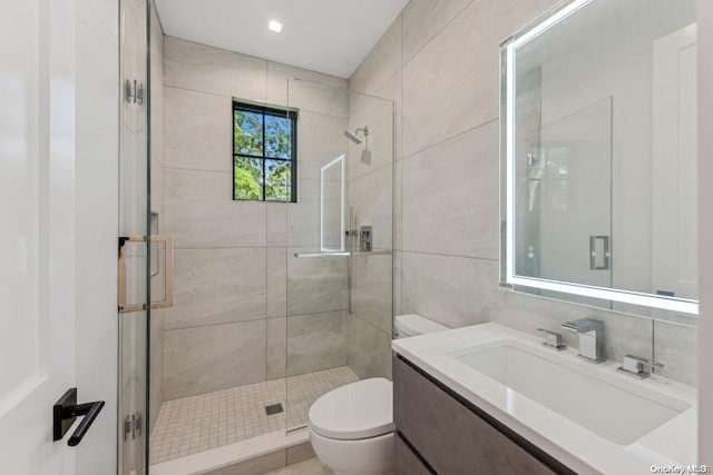 bathroom with vanity, backsplash, toilet, tile walls, and an enclosed shower