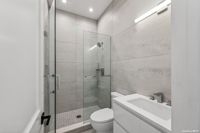 bathroom with vanity, toilet, and a shower with shower door