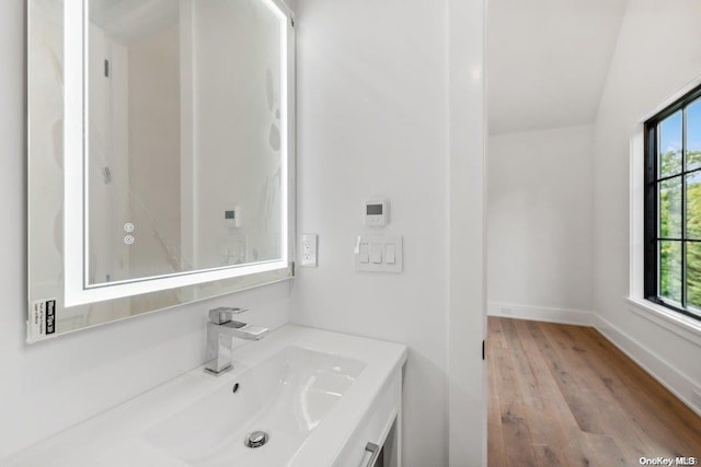 bathroom featuring lofted ceiling, wood-type flooring, and vanity