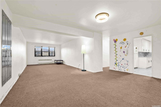 carpeted empty room with sink and radiator