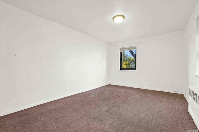 carpeted empty room with radiator heating unit