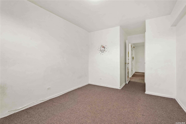 spare room with dark carpet