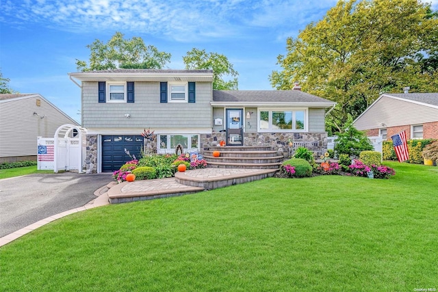 tri-level home featuring a garage and a front lawn