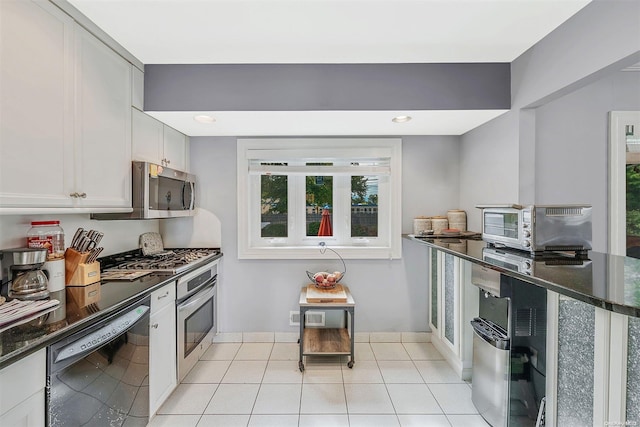 kitchen featuring white cabinets, light tile patterned floors, and stainless steel appliances