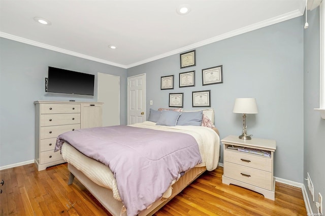 bedroom featuring ornamental molding and light hardwood / wood-style flooring