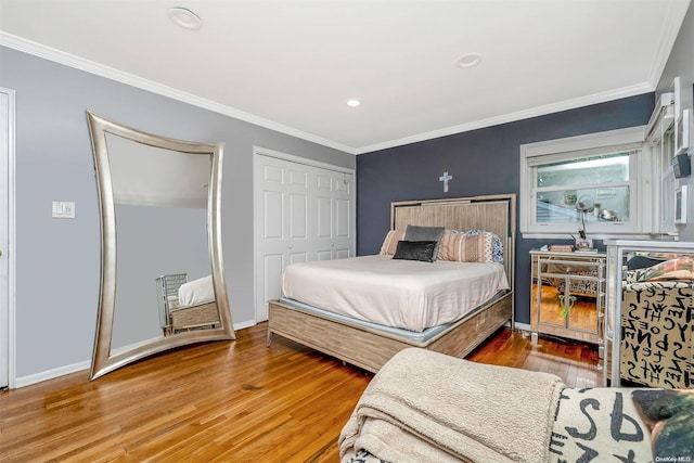 bedroom featuring a closet, ornamental molding, and hardwood / wood-style flooring