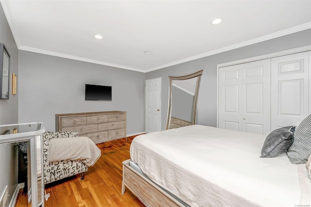 bedroom featuring a closet, hardwood / wood-style floors, and ornamental molding