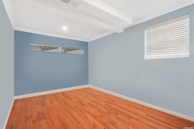 unfurnished room with a wealth of natural light, ornamental molding, and hardwood / wood-style flooring