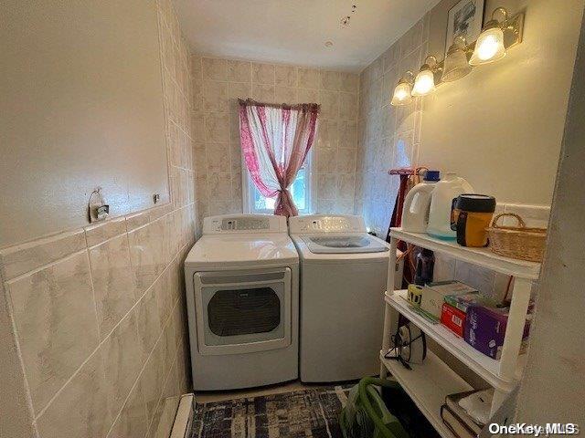 laundry area featuring washer and dryer and tile walls