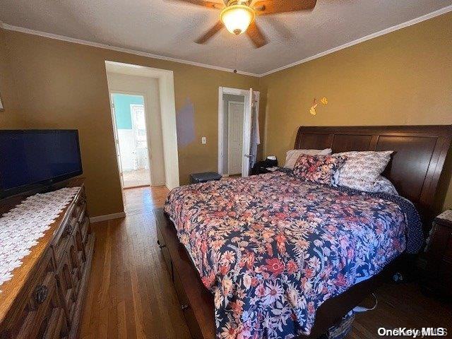 bedroom featuring hardwood / wood-style flooring, ceiling fan, and ornamental molding