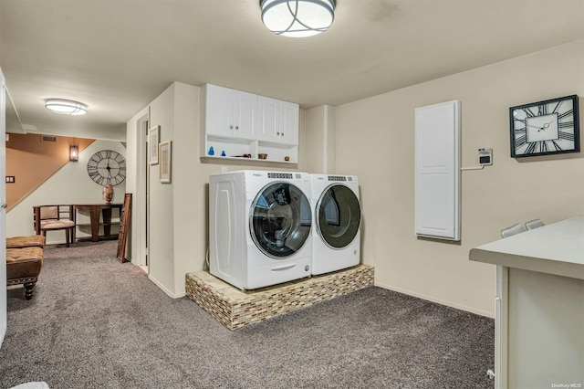 laundry room with dark colored carpet, washing machine and dryer, and cabinets