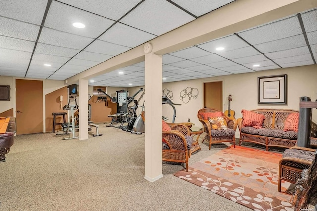 exercise area featuring carpet flooring and a drop ceiling