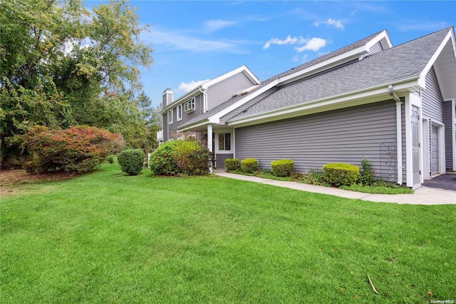 view of side of home featuring a garage and a yard