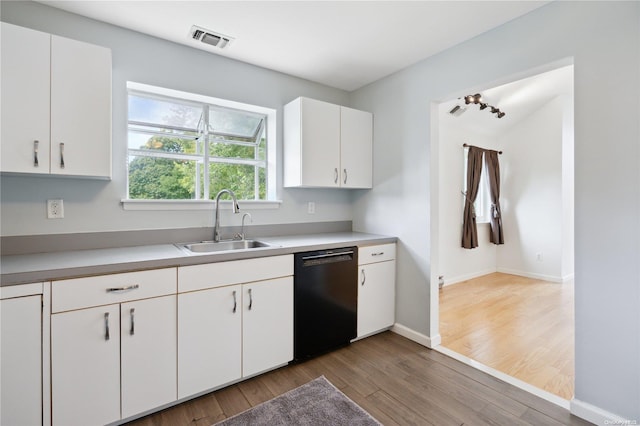 kitchen with hardwood / wood-style flooring, sink, white cabinetry, and black dishwasher