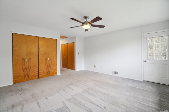 unfurnished bedroom with ceiling fan and light colored carpet