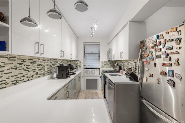 kitchen featuring decorative backsplash, white cabinets, light hardwood / wood-style floors, and appliances with stainless steel finishes