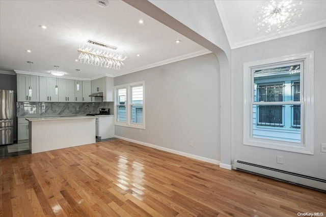 kitchen with baseboard heating, kitchen peninsula, crown molding, light hardwood / wood-style floors, and appliances with stainless steel finishes