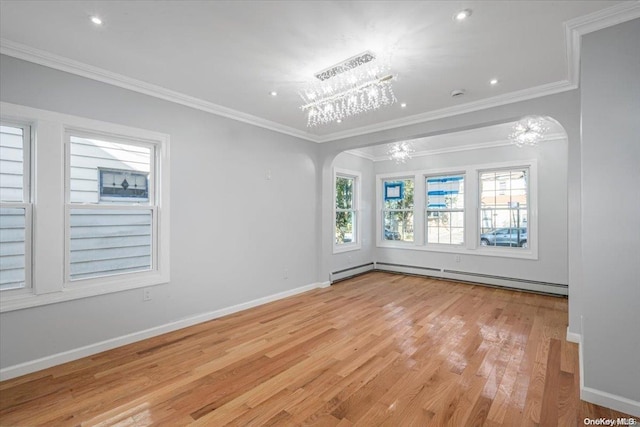 empty room featuring a notable chandelier, light wood-type flooring, crown molding, and a baseboard heating unit