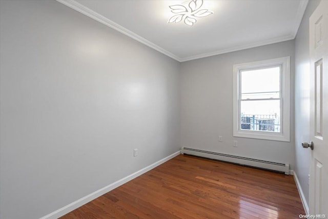 spare room with hardwood / wood-style flooring, baseboard heating, and ornamental molding