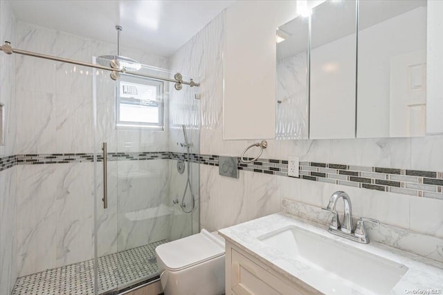 bathroom featuring vanity, toilet, a shower with shower door, and tile walls