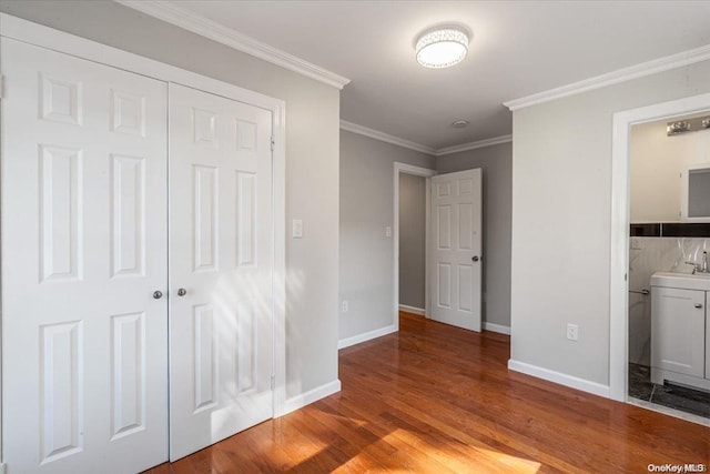 unfurnished bedroom with connected bathroom, light hardwood / wood-style floors, a closet, and crown molding