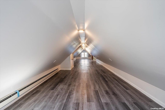 interior space featuring lofted ceiling, dark hardwood / wood-style flooring, and a baseboard heating unit