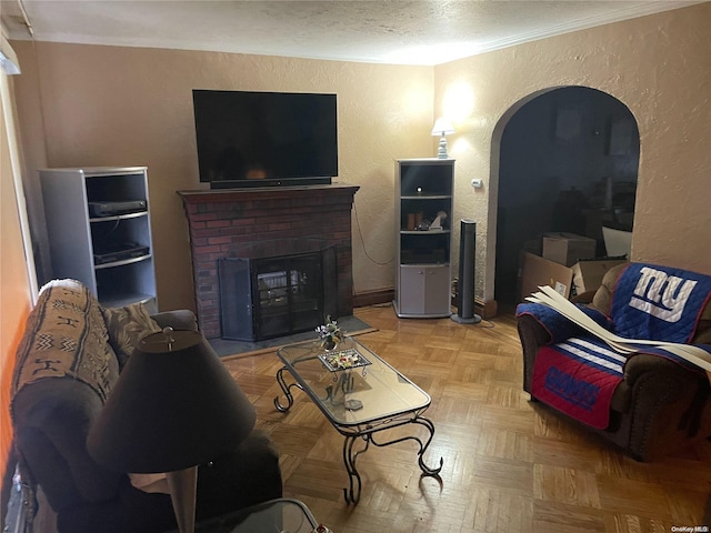 living room featuring light parquet floors, a brick fireplace, and crown molding