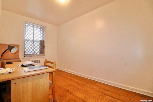 office featuring vaulted ceiling and light hardwood / wood-style flooring